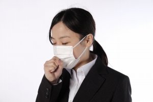マスクをして咳き込む女性
