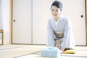 お歳暮を持参した着物女性